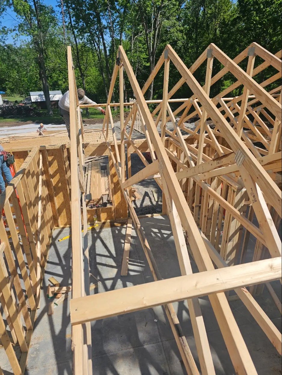 Wooden house framing under construction with exposed roof trusses